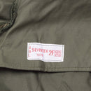 Close-up of genuine Belgian military jacket label sewn inside an olive green vintage BDU hooded parka.