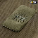 Close-up of breathable olive fabric with M-TAC military style patch on a lightweight tactical polo shirt