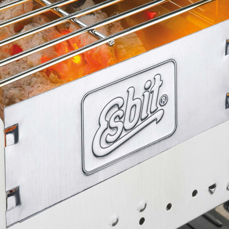 Close-up of Esbit charcoal grill showing burning charcoal and metal grill grate for outdoor cooking