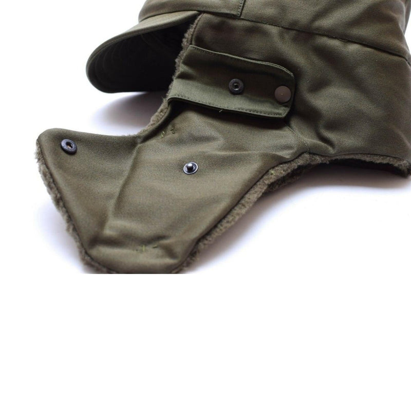 Vintage genuine Austrian Army winter cap in olive with ear flaps, visor, and military insignia badge.