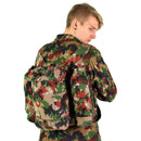 Man wearing genuine Swiss army Alpen camo backpack made of durable canvas with multiple compartments and suspenders