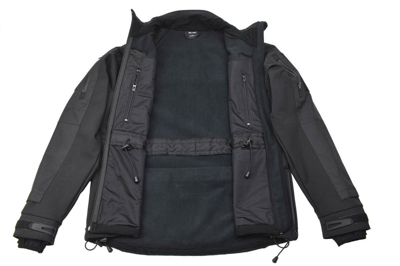 Black MIL-TEC softshell jacket with zippered pockets, windproof, water-resistant, and vented armpits for breathability.