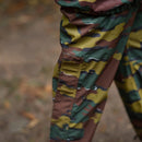 Close-up of waterproof Belgian military pants in jigsaw camouflage with reinforced knee and pocket detail outdoors
