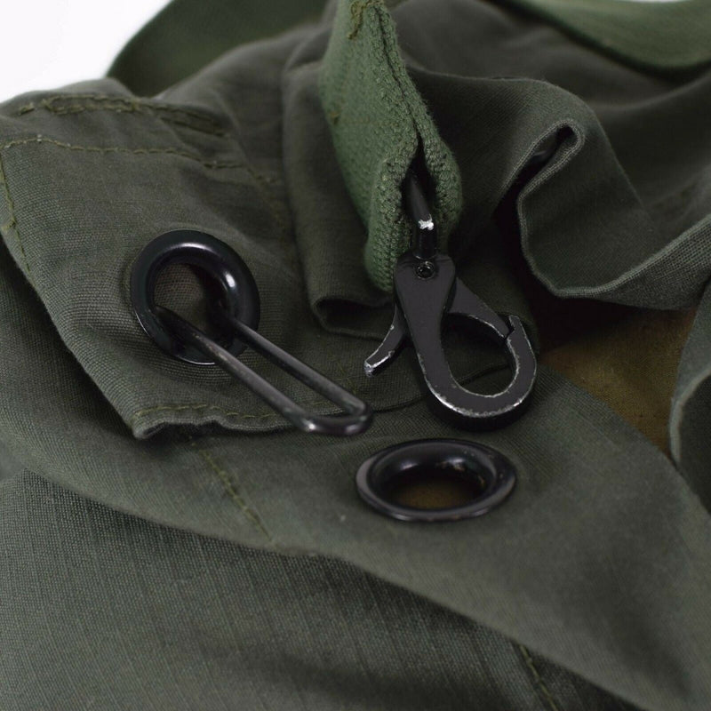 Close-up of olive green ripstop fabric with metal hardware on the original Dutch military duffel bag.