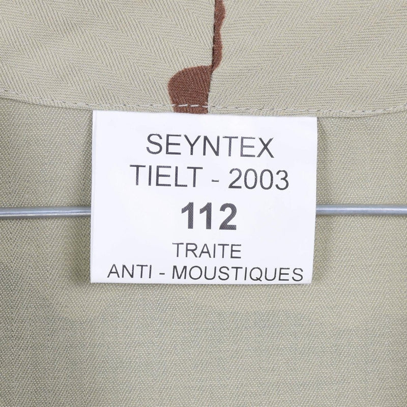 Close-up of a fabric label on a desert camouflage tactical combat shirt with anti-mosquito treatment details.