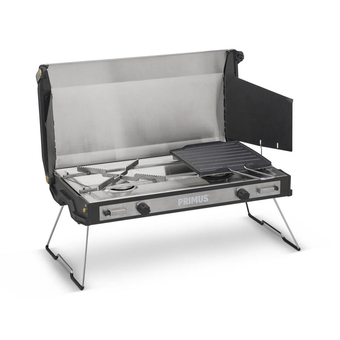 Primus Tupike Outdoor-Campingkocher mit zwei Gasbrennern, klappbaren Beinen und antihaftbeschichteter Grillplatte für vielseitiges Kochen.