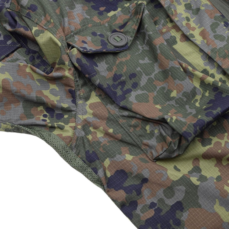 Close-up of TACGEAR Flecktarn camo jacket showing ripstop fabric, buttoned pocket, and green, brown, and black camouflage pattern.