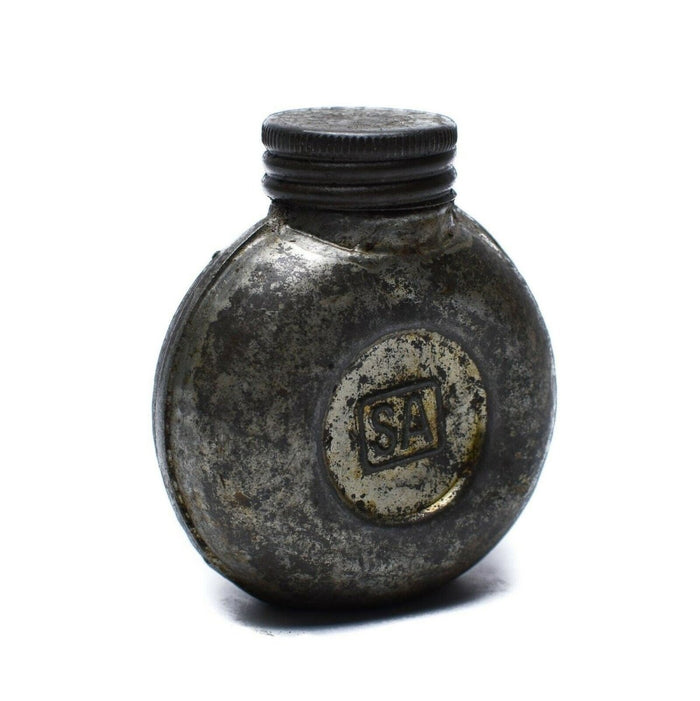 Vintage-Tintenflasche aus Metall mit „SA“-Logo auf weißem Hintergrund